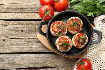 Tasty stuffed mushrooms served on wooden table, flat lay. Space for text