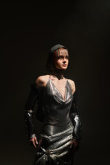 Elegant woman adorned in knightcore fashion embodies castle core aesthetics in a dimly lit space
