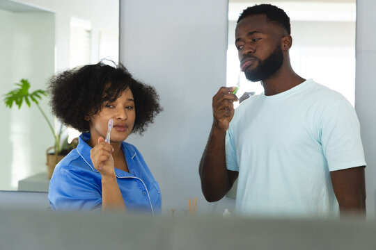 In bathroom, couple brushing teeth together, starting their morning routine