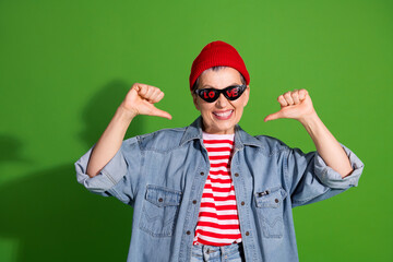 Excited middle aged woman in casual denim outfit with red beanie and stylish glasses gesturing happily