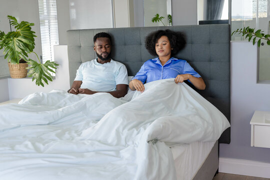 Couple relaxing in bed, enjoying peaceful morning together at home