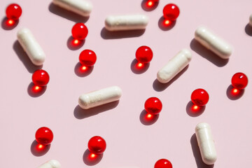 White Capsules and Red Vitamin Pills. Medicine and Supplement Concept.
