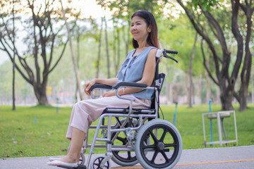 A smiling elderly woman in a wheelchair sits outdoors with her caregiver, sharing a hopeful...