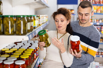 Portrait of an couple buying a salted tomatoes and cucumbers at the grocery store