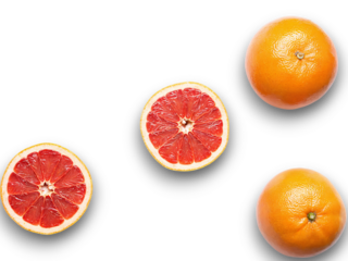 Fresh oranges and sliced grapefruit displayed on a clean surface showcasing vibrant colors and textures