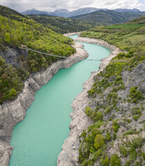 Obraz premium Himalayan footbridge over Lake Monteynard-Avignonet in the French Alps near Grenoble, suspended walkway in scenic mountain landscape, popular hiking destination