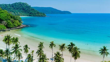 A breathtaking tropical beach in Thailand, where soft white sand meets vibrant turquoise waters. Lush palm trees frame the shore, inviting visitors to relax and enjoy the sun.