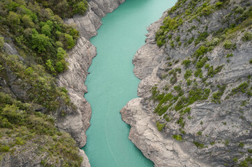 Scenic view of Lake Monteynard-Avignonet in a canyon in the French Alps near Grenoble, turquoise mountain lake surrounded by alpine peaks and forests