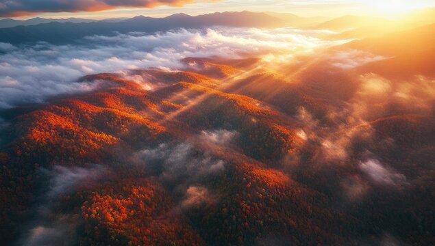 Autumnal mountain range bathed in golden sunrise light, with clouds