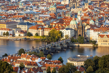 Visitors stroll across Charles Bridge, enjoying stunning sunset views of Prague