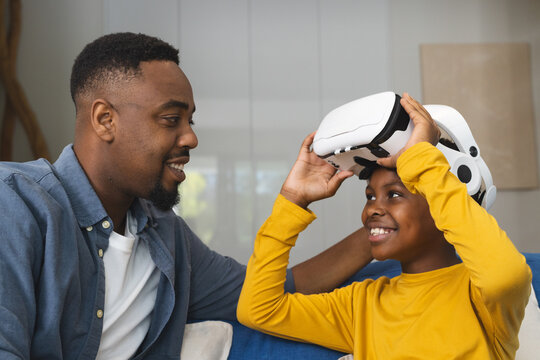 African American father and son enjoying virtual reality experience together at home