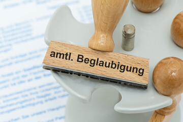 Ein Holzstempel ist beschriftet mit dem Aufdruck amtliche Beglaubigung
