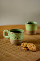 duas xícaras de café com biscoitos sobre a mesa