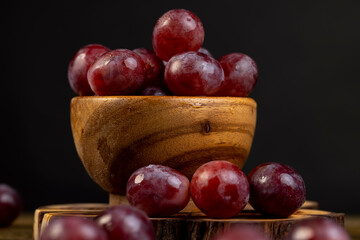 grapes after washing the berries, clean wet grapes safe for eating, grapes in a wooden bowl