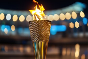 Golden torch ablaze at night, blurred city lights in background