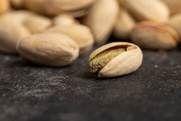 pistachios with green nuts inside, the salted pistachios on the table are more delicious, piled...