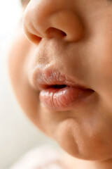 Obraz premium Macro Close-Up of Baby’s Lips and Nose in Warm Natural Light Highlighting Texture and Innocence