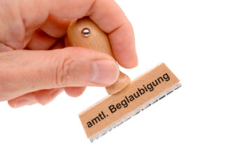 Ein Holzstempel ist beschriftet mit dem Aufdruck amtliche Beglaubigung