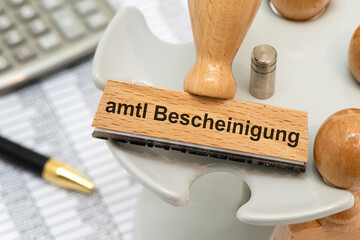 Ein Holzstempel ist beschriftet mit dem Aufdruck amtliche Bescheinigung