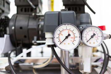 Analog pressure gauges on the compressor.