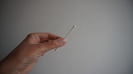 hand holding a cotton swab on white
