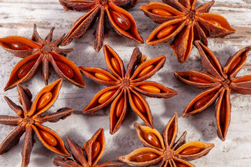 Group of small stars of dried anise (Illicium verum) on wooden plank, close up
