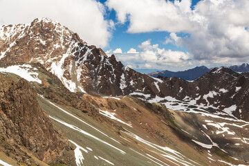 Aerial view over snow-covered ranges of mountains from mountain pass over the lake Ala-Kul. Tien Shan. Kyrgyzstan