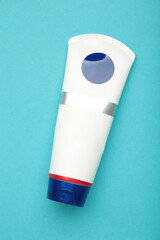 Cosmetic tube on blue background. Vertical photo.