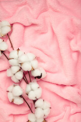 Pink soft plaid with cotton flower. Vertical photo