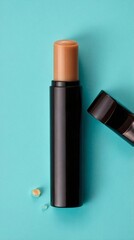 Obraz premium Tan Lip Balm in Black Tube and Cap on Cyan Background