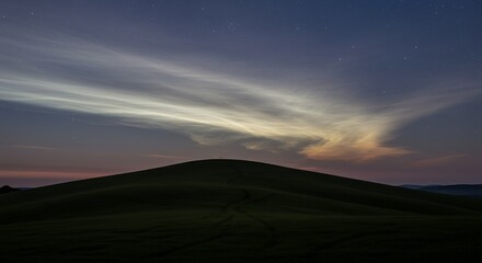 Obraz premium Noctilucent Clouds Over a Green Hill