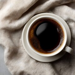 A white cup of dark coffee on a beige linen cloth