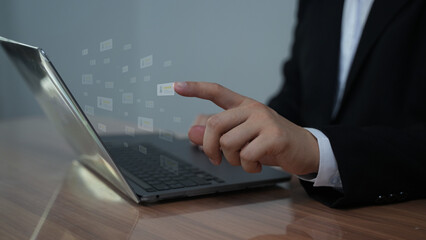 A businessman interacting with a laptop, selecting options from a transparent digital interface....