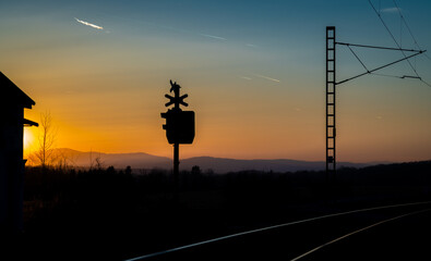 Railway crossing with red lights with sunset evening near Trocnov village