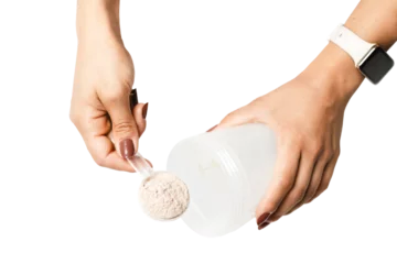 Fototapete Woman's hands with measuring spoon puts portion of whey protein powder into a shaker, making protein drink cocktail, isolated on transparent background, top view © O.Farion