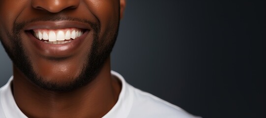 Happily smiling African American young man with perfectly white even teeth. Tooth whitening concept. Smiling mouth close up. Picture with copy space.