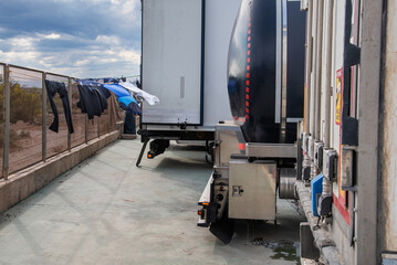 Naklejka premium Laundry hanging on a drying rack attached to the rear of a truck, illustrating life on the road for international drivers during long hauls.