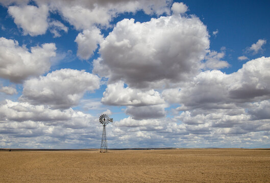 USA, Washington State. Highway 26 just west of Washtucna with clouds over wheat fields and windmill