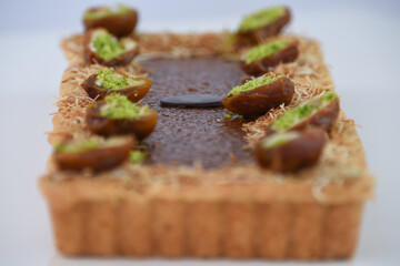 Pistachio and Date rectangular Tart garnished with halves of dates filled with vibrant green...