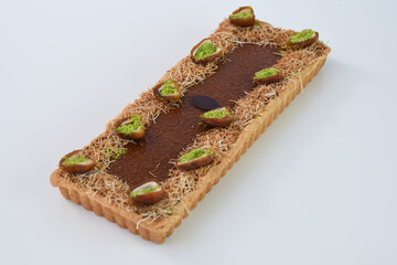 Pistachio and Date rectangular Tart garnished with halves of dates filled with vibrant green...