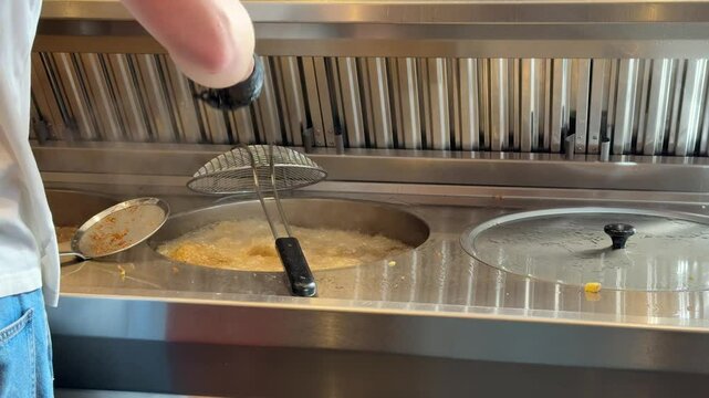 Pr&eacute;paration de frites dans une friterie belge et une friteuse professionnelle.
