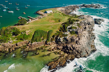 Rocky coastline with ocean and waves in Brazil. Drone view of Ponta das Campanhas in Floripa