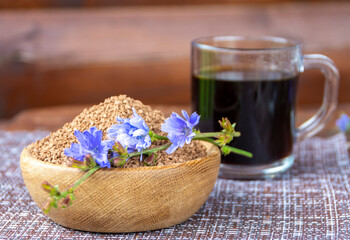 Ground chicory root, chicory flowers and chicory drink on a rustic wooden background. Alternative medicine. Healthy drinks