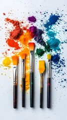 Vibrant powdered pigments scattered around paintbrushes in rainbow hues