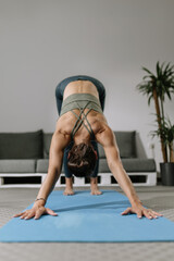 Yoga practice in a cozy living room setting featuring a woman in downward dog pose