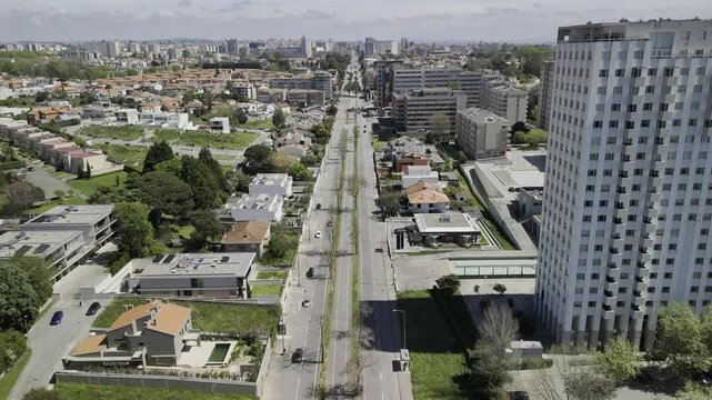 Drone flies east down Avenida Boavista in the Beco da Carreiras neighborhood on sunny afternoon in Porto, Portugal