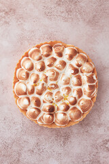 lemon meringue cake, golden brown, toasted, on a light table, no people,