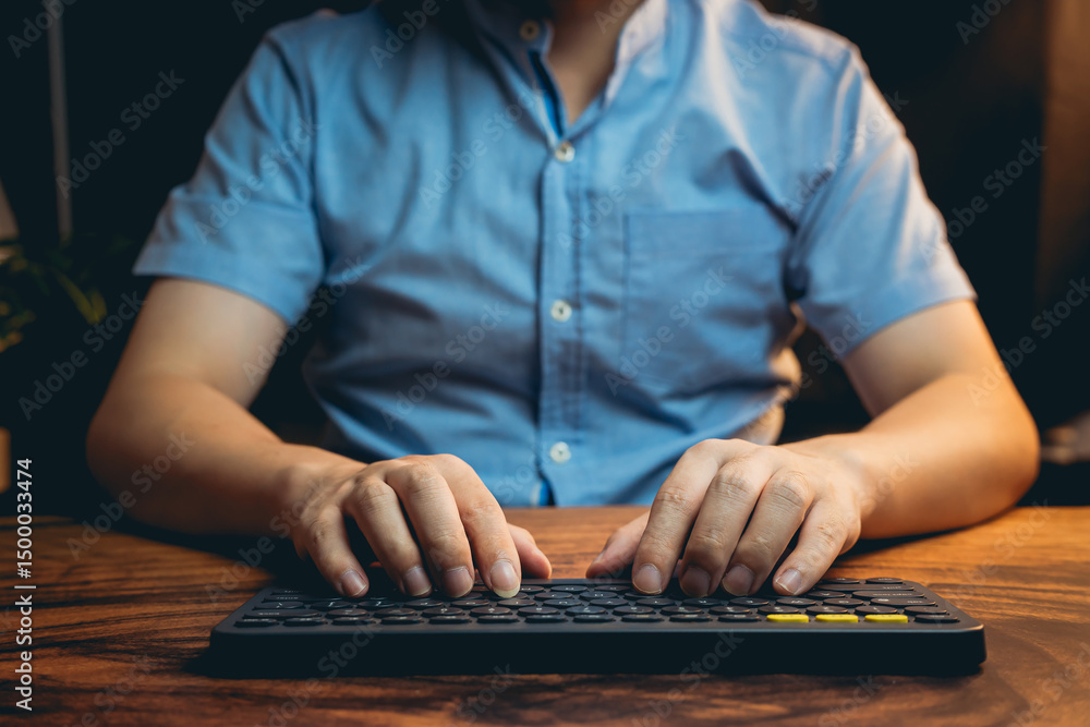 Poster person typing on keyboard with focus in home office setting during evening hours