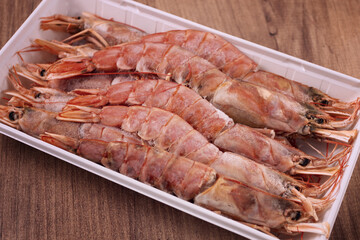 Fresh frozen Argentine shrimp, laid out in a container, top view, no people,