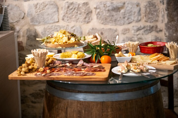 Traditional wooden board with assorted Italian cured meats and salami ready to serve